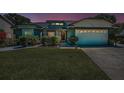 Exterior shot of a single-Gathering home featuring landscaped yard and a two-car garage at dusk at 8904 Beeler Dr, Tampa, FL 33626