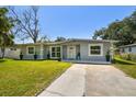 Charming single-story home with well-maintained lawn and landscaping in front at 6914 N Ola Ave, Tampa, FL 33604