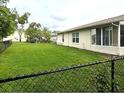 Spacious backyard featuring a green lawn and a black chain link fence at 10627 Mira Vista Dr, Port Richey, FL 34668