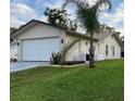 An exterior view shows the home, lawn, and landscaping. A palm tree and other greenery enhance the curb appeal at 10627 Mira Vista Dr, Port Richey, FL 34668