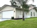 Side view of house with an attached garage and well-kept lawn at 10627 Mira Vista Dr, Port Richey, FL 34668