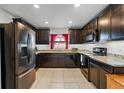 Modern kitchen featuring granite countertops, stainless steel appliances, and dark wood cabinetry at 1102 Wynnmere Walk Ave, Ruskin, FL 33570
