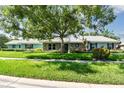 Charming single-story home with stone facade, lush landscaping, and a sidewalk leading to the house at 12020 66Th Ave, Seminole, FL 33772