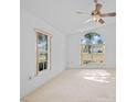 Bright main bedroom with large windows, neutral carpet, and a ceiling fan, offering a peaceful retreat at 1247 Venetia Dr, Spring Hill, FL 34608