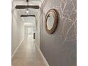 A hallway with decorative walls, recessed lighting, and access to kitchen and living room at 12620 Flatwood Creek Dr, Gibsonton, FL 33534
