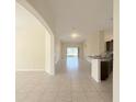 Spacious living area featuring tiled floors, arched doorways, and seamless flow to the kitchen at 13181 Royal Pines Ave, Riverview, FL 33579