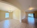Bright open living space featuring tile floors, an arched doorway, and sliding glass doors to a lanai at 13181 Royal Pines Ave, Riverview, FL 33579