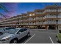 Condo building with multiple levels of units, each having balconies and ground-level parking with secure access at 1420 Bayshore Blvd # 409, Dunedin, FL 34698