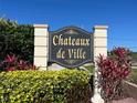 Elegant community entrance sign surrounded by manicured landscaping at 1512 Chateaux De Ville Ct, Clearwater, FL 33764