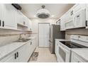 Updated kitchen with white cabinets, stainless steel appliances, and modern fixtures at 1515 12Th Se Ct # 55, Largo, FL 33771