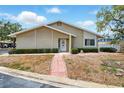 Inviting one-story home with brick accents, tidy landscaping, and a brick walkway leading to the front door at 1671 Cape Ann Ne Ave # 4, St Petersburg, FL 33702