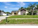 Quaint one-story home with stone and wood accents, lush lawn, and mature trees at 18426 Sterling Silver Cir, Lutz, FL 33549