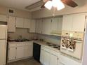 Functional kitchen design featuring white cabinetry and standard appliances at 2450 Canadian Way # 6, Clearwater, FL 33763