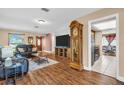 Inviting living room with wood floors, comfortable seating, and a view into the adjacent kitchen and dining area at 2597 Bramblewood E Dr, Clearwater, FL 33763