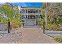 A grand three-story waterfront home featuring a private driveway, a multi-car garage and multiple balconies at 273 Shore, Palm Harbor, FL 34683