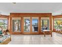 Bright and airy living room with multiple windows and French doors leading to outdoor balconies with water views at 273 Shore Dr, Palm Harbor, FL 34683