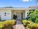Inviting entryway with double doors, modern lighting, and lush landscaping leading to the entrance of the home at 2850 Allapattah Dr, Clearwater, FL 33761