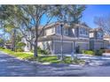 Corner lot townhome featuring a two-car garage, neutral paint, tiled roof and manicured landscaping at 3292 Covered Bridge E Dr, Dunedin, FL 34698