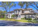 Townhome featuring neutral paint, tiled roof and manicured landscaping at 3292 Covered Bridge E Dr, Dunedin, FL 34698