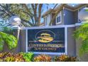 Community entrance sign reading Covered Bridge Townhomes with manicured landscaping at 3292 Covered Bridge E Dr, Dunedin, FL 34698