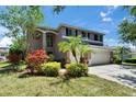 Two-story home featuring a three-car garage, landscaping, and trimmed lawn at 3314 Cypress Landing Dr, Valrico, FL 33596