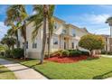 Well-maintained front yard featuring palm trees, colorful foliage and a manicured lawn at 339 Manatee Ln, Tarpon Springs, FL 34689