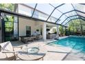 A beautiful screened pool with a fire table and an outdoor kitchen invites entertainment and relaxation at 4204 W San Juan St, Tampa, FL 33629