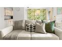 Cozy living room featuring a comfortable sofa with stylish pillows and a leafy wallpaper accent wall at 4215 E Bay Dr # 1806D, Clearwater, FL 33764