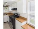 Functional kitchen features white cabinets, laminate countertops, and a black oven range at 4937 Steel Dust Ln, Lutz, FL 33559