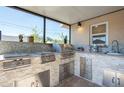 An outdoor kitchen with stainless steel appliances, granite countertops, and a built-in sink, perfect for entertaining at 6328 S Harold Ave, Tampa, FL 33616