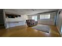 Spacious living room features wood floors and a cozy reading area with a comfortable couch and natural lighting at 8623 Stonehedge Way, Hudson, FL 34667