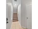 Bright hallway featuring tile flooring, a staircase with carpeted steps, and a convenient storage closet at 956 Sombra St, Tampa, FL 33619