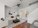 Staged living room with hardwood floors, modern decor, ceiling fan, and natural light, creating a cozy ambiance at 956 Sombra St, Tampa, FL 33619