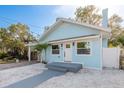 Charming light blue home featuring a quaint front yard with tasteful landscaping elements at 110 Kenwood Ave, Clearwater, FL 33755