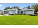 Charming one-story home with fresh landscaping and a spacious green lawn under a blue sky at 11218 Sun Tree Rd, Hudson, FL 34667