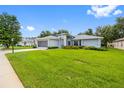 Charming one-story home with fresh landscaping, a screened garage, and a spacious green lawn at 11218 Sun Tree Rd, Hudson, FL 34667