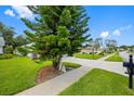 Serene neighborhood street featuring lush green lawns, sidewalks, and mature trees, perfect for a peaceful setting at 11218 Sun Tree Rd, Hudson, FL 34667