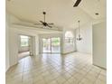 Spacious living room with neutral tile flooring, ceiling fans, and sliding door access to outdoor space at 114 Clays Trl # 114, Oldsmar, FL 34677