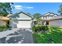Beautiful single-story home with a two car garage, landscaped yard, and a red front door at 11932 Whisper Creek Dr, Riverview, FL 33569