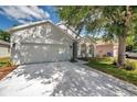 Street view of a well-maintained home featuring a two car garage and lovely landscaping at 12351 Ridgedale Dr, Hudson, FL 34669