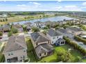 Panoramic aerial view showcasing a residential neighborhood, lake, and backyard oasis with screened pool and trampoline at 17537 Brighton Lake Rd, Land O Lakes, FL 34638
