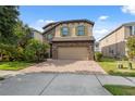 Beautiful home with a brick driveway, two-car garage, stone accents, and well-maintained landscaping at 17537 Brighton Lake Rd, Land O Lakes, FL 34638
