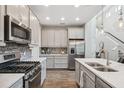 Modern kitchen features stainless steel appliances, stylish backsplash, ample cabinetry, and a functional island at 17537 Brighton Lake Rd, Land O Lakes, FL 34638