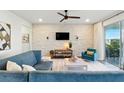 Cozy living room featuring a decorative brick wall, ceiling fan, comfortable seating, and natural light at 18172 Ramble On Way, Land O Lakes, FL 34638
