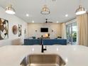 Stylish living room featuring modern lighting, a large sectional sofa, and a sliding glass door to the patio at 18172 Ramble On Way, Land O Lakes, FL 34638