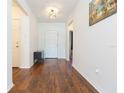 Inviting foyer with gleaming hardwood floors, modern light fixture, and neutral wall paint at 19032 Malinche Loop, Spring Hill, FL 34610