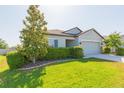 Beautiful single-story home featuring manicured lawn and mature landscaping in a neighborhood at 19032 Malinche Loop, Spring Hill, FL 34610