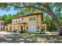 Mediterranean-style home with arched entryway and balcony, offering outdoor living space and lush surroundings at 1966 Freedom Dr, Clearwater, FL 33755