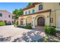 Close-up of the home's entry featuring an arched porch, columns, and a brick driveway at 1966 Freedom Dr, Clearwater, FL 33755