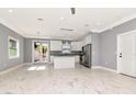 Bright kitchen with white cabinets, stainless steel appliances, granite countertops, and an island with elegant marble tile at 212 W Floribraska Ave, Tampa, FL 33603